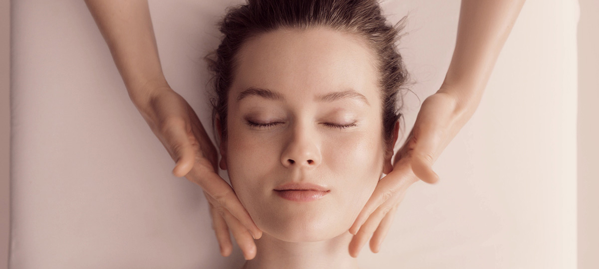 GUERLAIN MODEL RECEIVING A FACIAL WITH HANDS MASSAGING THE FACE